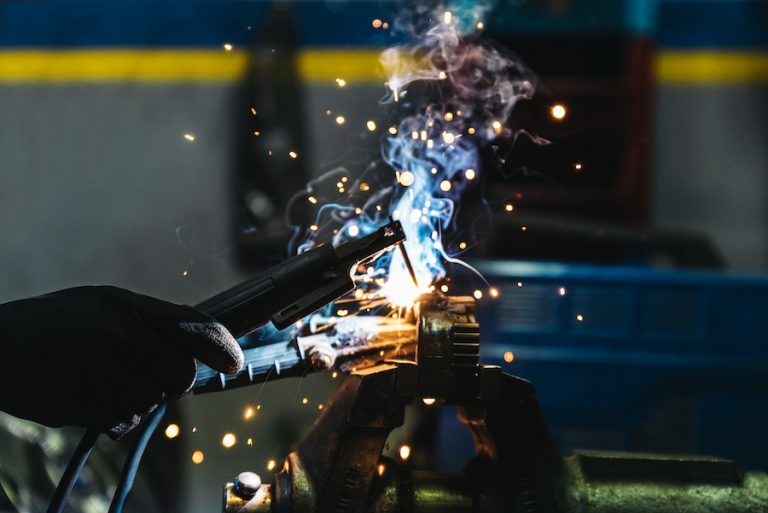 Professional Mechanic welding in Garage.