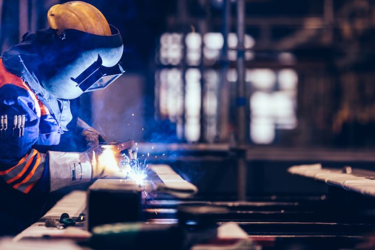 Worker welding in a factory. Heavy industry, welder work